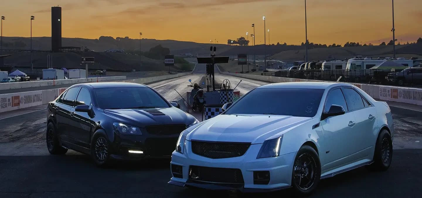 GM cars staged at a drag strip at sunset